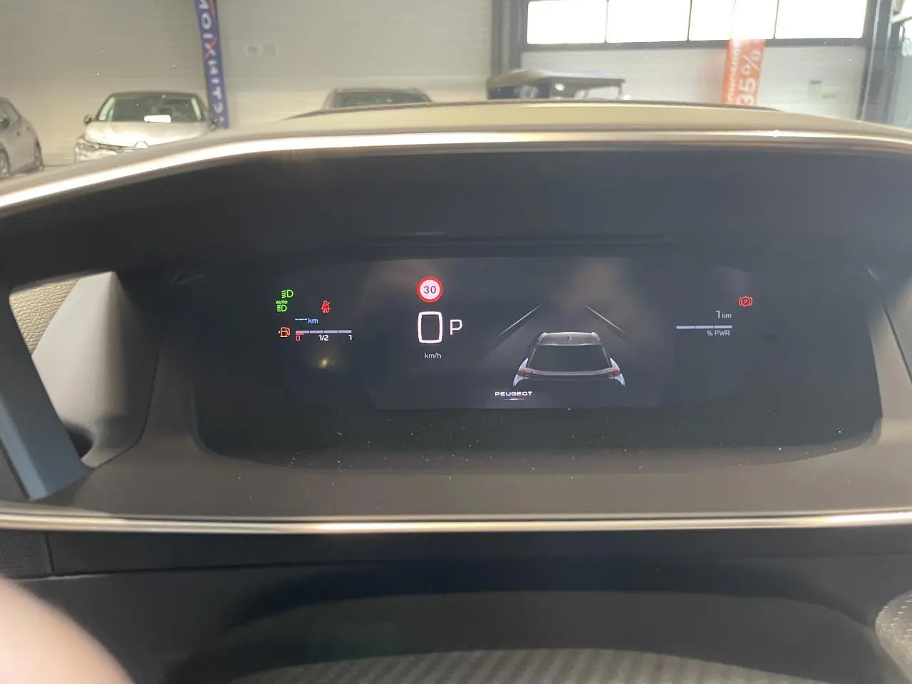 Vue rapprochée du tableau de bord numérique du Peugeot 2008 Hybrid 2026 affichant la vitesse et l'état du véhicule.