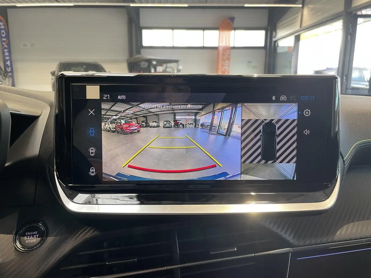 Écran tactile intérieur montrant la caméra de recul et vue 360° dans un Peugeot 2008 bleu hybride, tableau de bord noir.