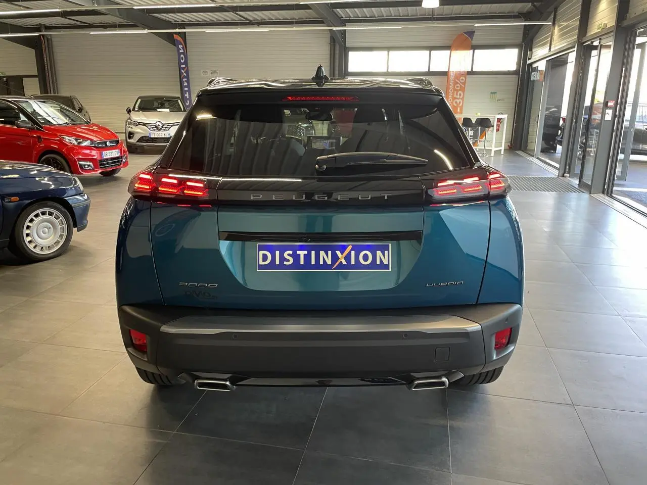 Vue arrière d'un Peugeot 2008 bleu métallisé avec feux arrière LED 3 griffes et double sortie d'échappement chromée.