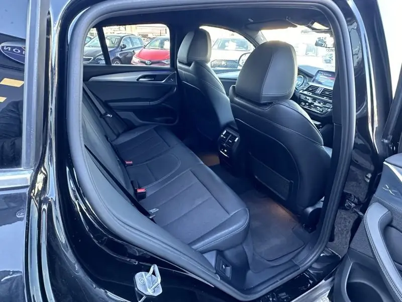 Vue intérieure arrière côté gauche du BMW X4 X Line 2019 gris foncé, montrant les sièges en cuir noir et la console centrale.