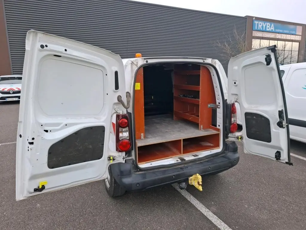 Vue arrière d’un Citroën Berlingo blanc 2019 avec portes ouvertes et étagères en bois dans la zone de chargement.
