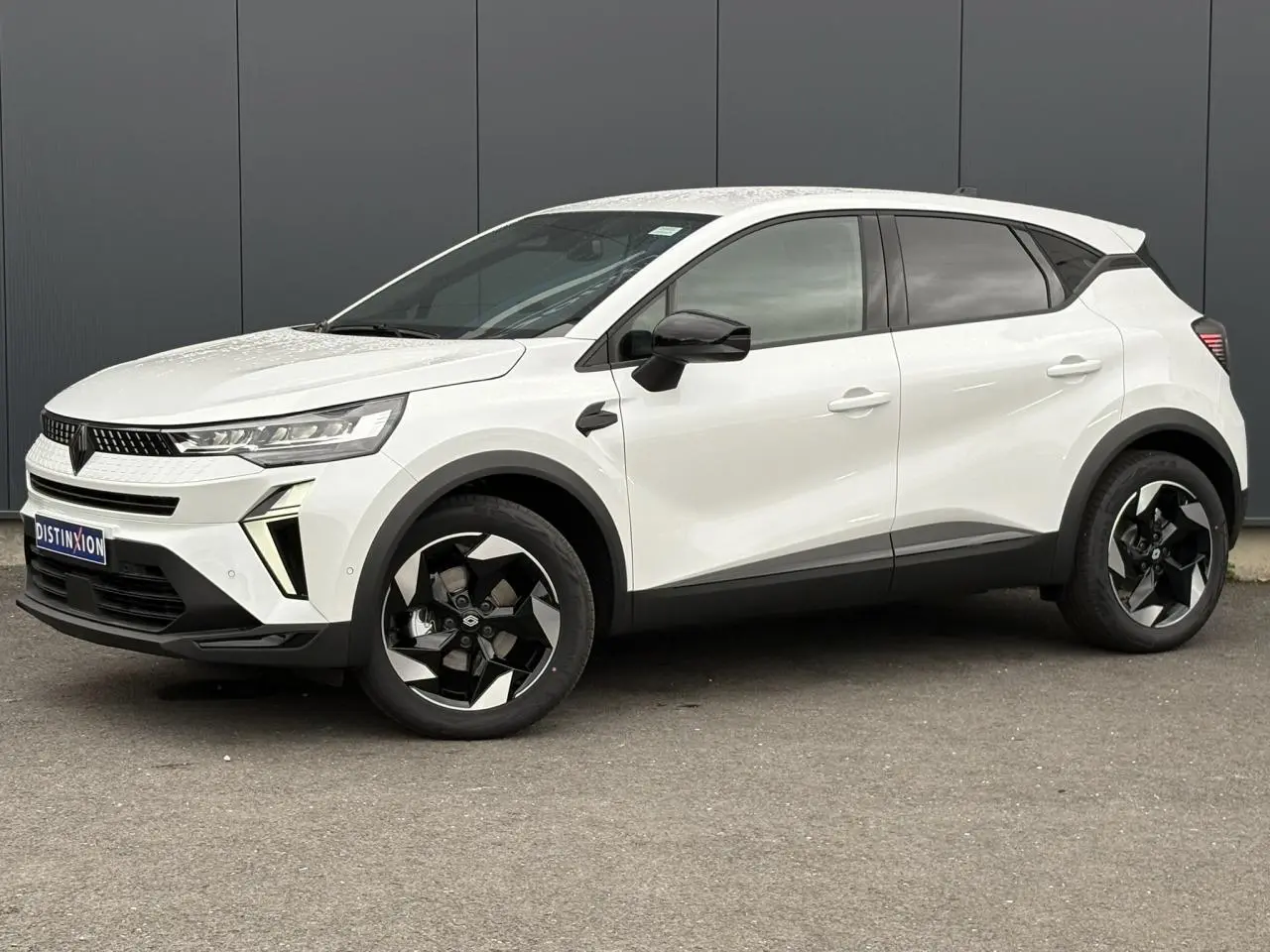 Renault Captur blanc nacré en vue de profil côté gauche, avec jantes noires et détails noirs contrastants.