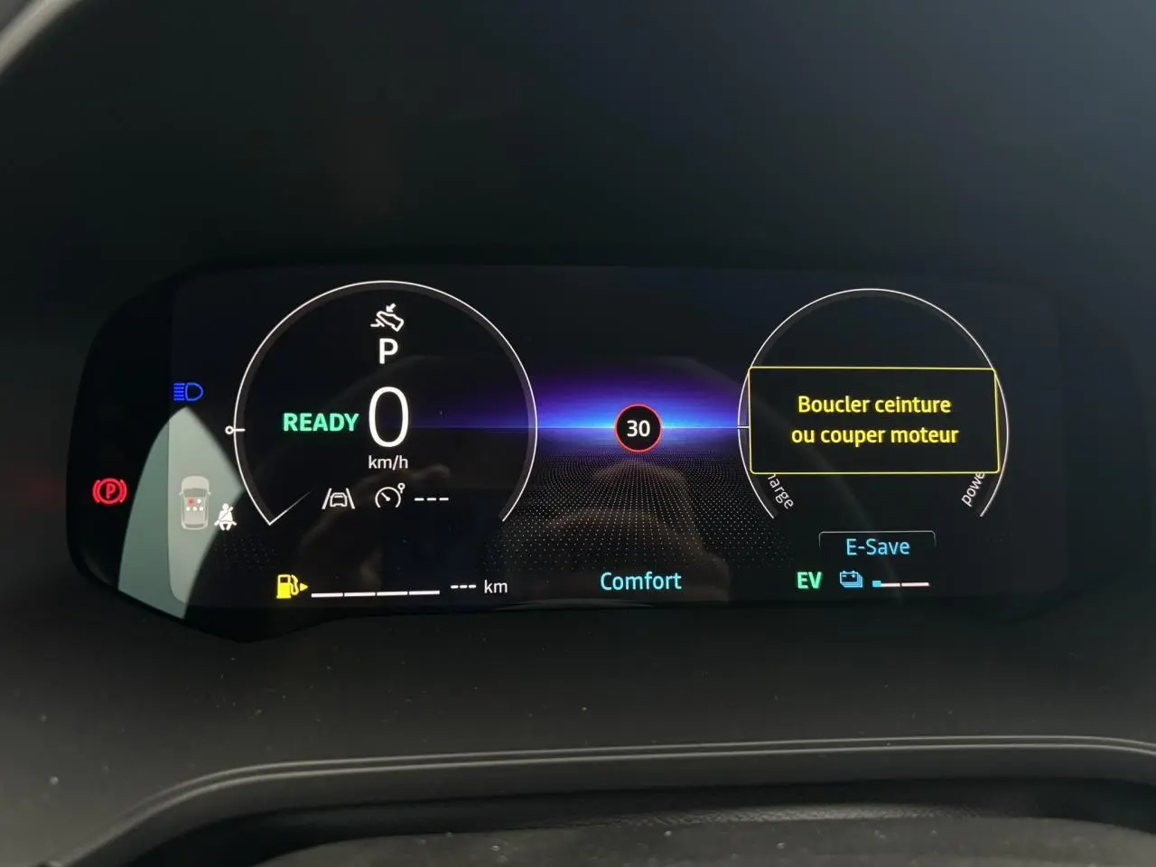 Tableau de bord numérique du Renault Captur 2026 affichant la vitesse à 0 km/h et mode Confort, avec alertes de sécurité visibles.