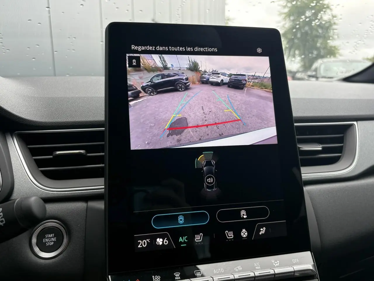 Vue intérieure du tableau de bord du Renault Captur blanc nacré, écran tactile affichant la caméra de recul.