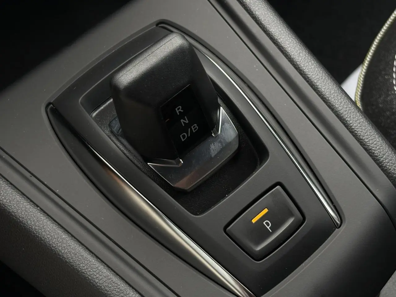 Gros plan sur le levier de vitesses automatique et bouton de parking du Renault Captur 2026, intérieur noir mat.