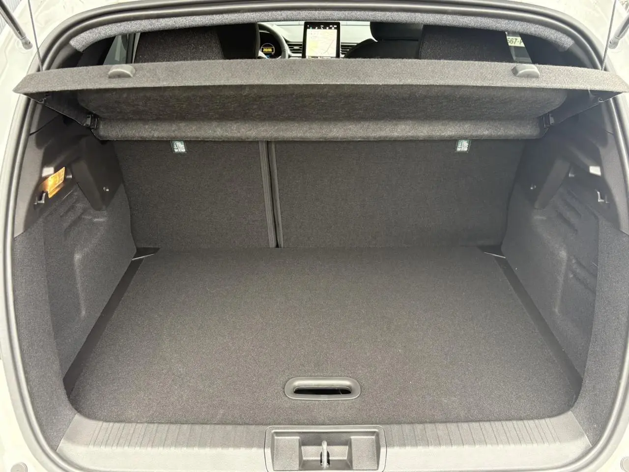 Coffre ouvert vu de l'arrière du Renault Captur blanc nacré, montrant un espace de chargement propre et bien fini.