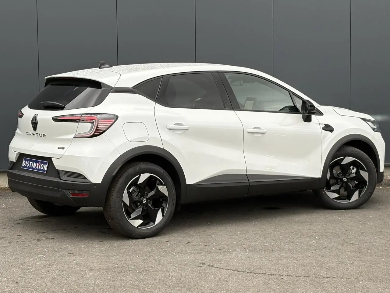 Renault Captur blanc nacré en vue profil droit, avec jantes 18 pouces noires et vitres surteintées.