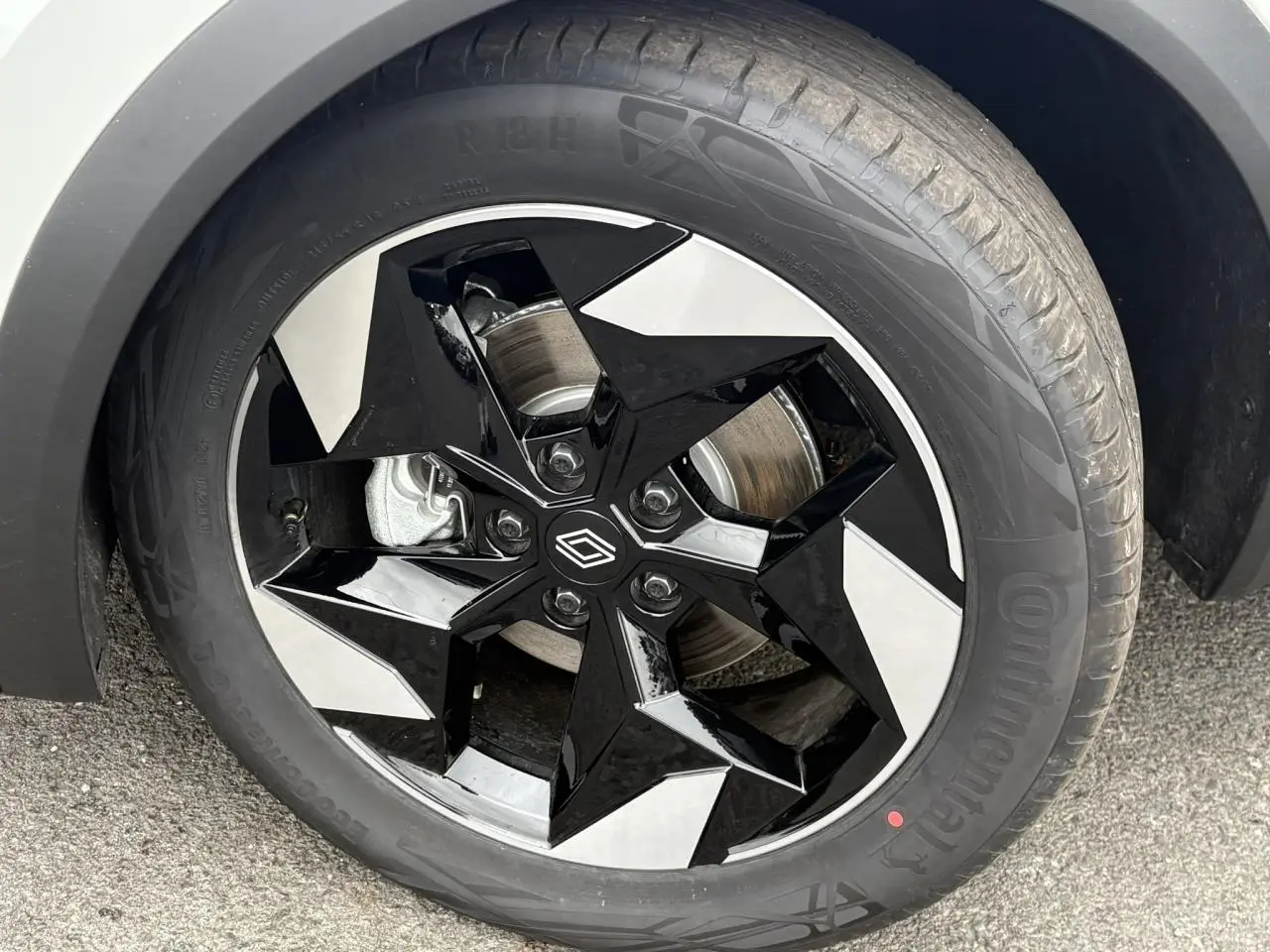Gros plan sur la jante aluminium 18 pouces bicolore noire et argent du Renault Captur blanc nacré.
