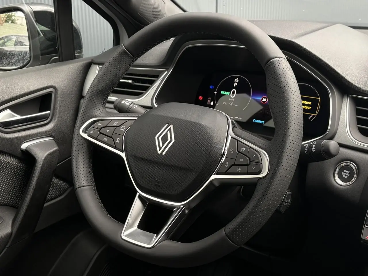 Intérieur du Renault Captur 2026 vu côté conducteur, volant noir avec commandes intégrées et tableau de bord numérique.