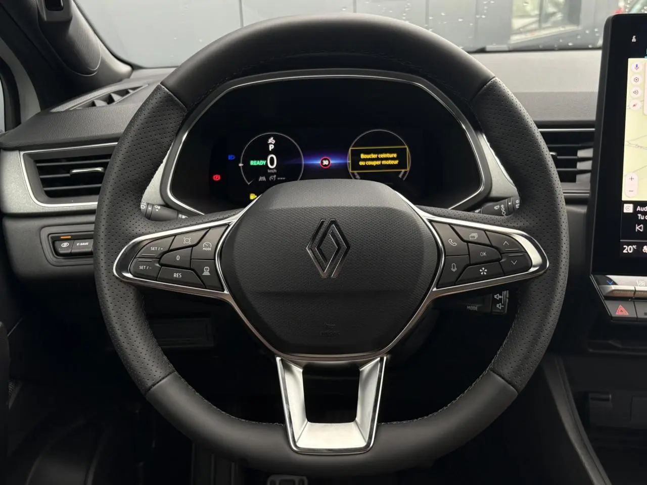 Vue frontale du volant noir en textile refined du Renault Captur 2026 avec tableau de bord numérique et commandes intégrées.
