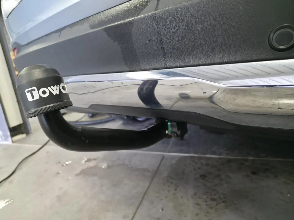Gros plan sur l'attelage noir avec capuchon Towcar sous le pare-chocs arrière gris métallisé du Mercedes GLC.
