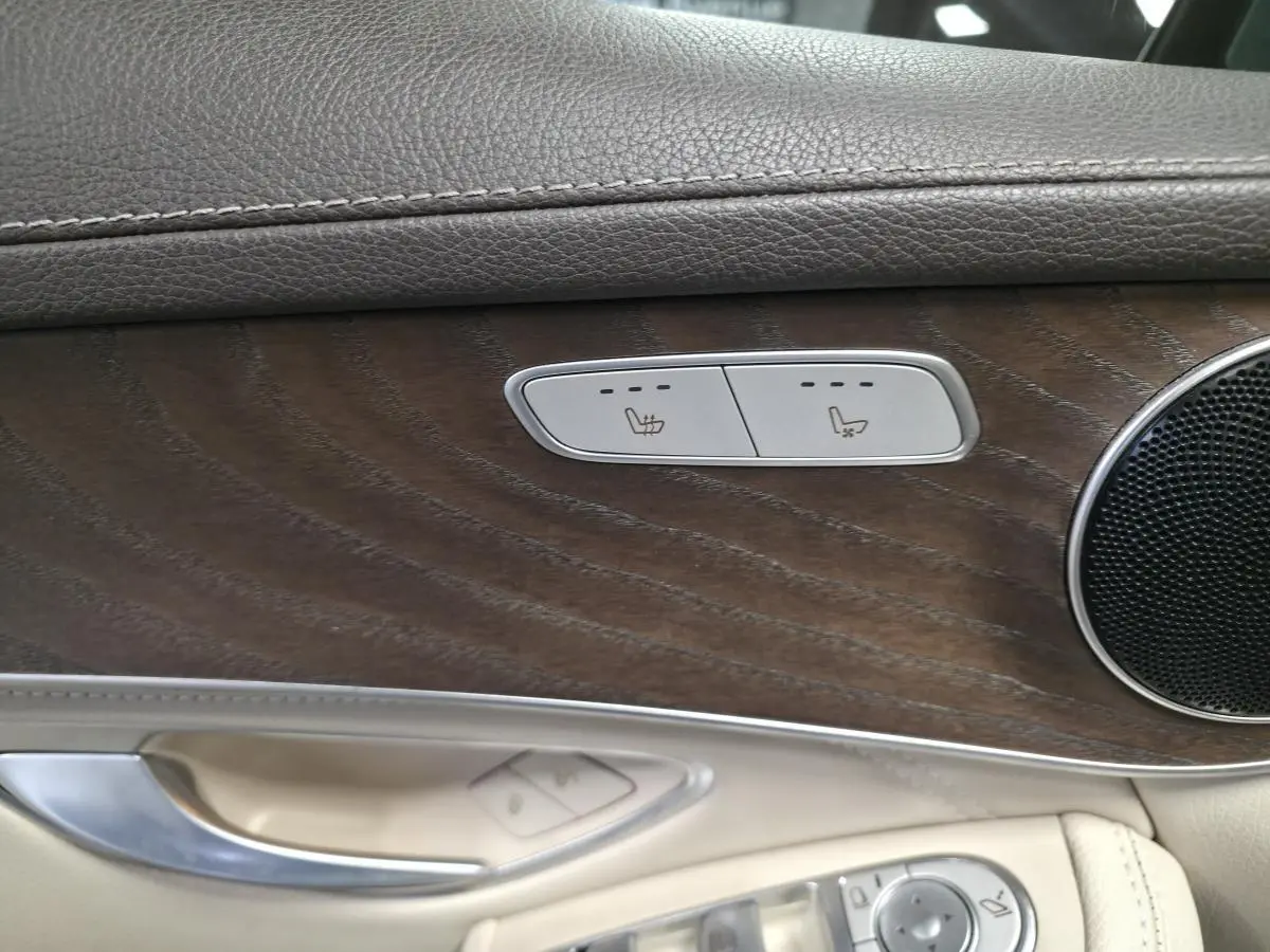 Détail de la porte côté gauche du Mercedes GLC 350 e gris, avec inserts bois et commandes sièges chauffants.
