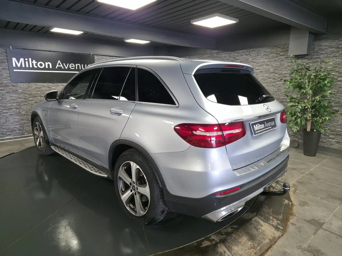 Mercedes GLC 350 e gris métallisé vu en 3/4 arrière droit avec attelage et jantes alliage 19 pouces.