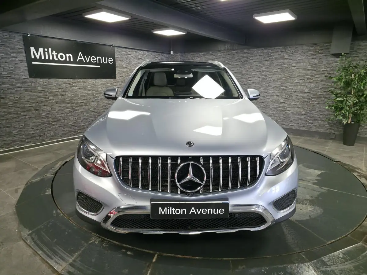 Vue avant d'un Mercedes GLC 350 e gris métallisé avec calandre verticale et logo étoile bien visible.