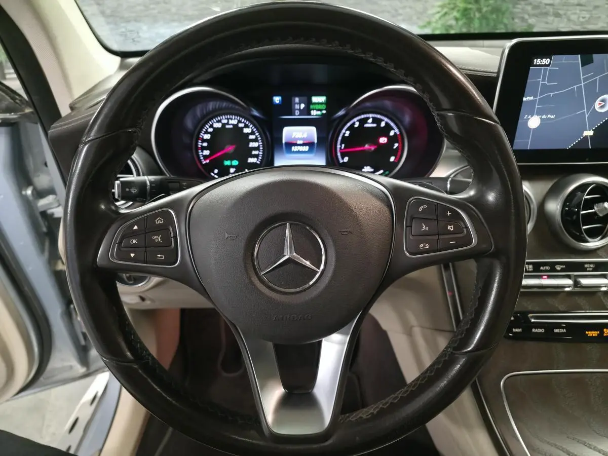 Vue intérieure centrée sur le volant cuir noir et le combiné d'instruments du Mercedes GLC 350 e hybride 2017.