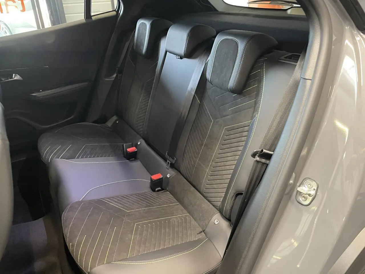 Vue intérieure côté droit des sièges arrière gris avec surpiqûres jaunes du Peugeot 2008 Hybrid 2026.