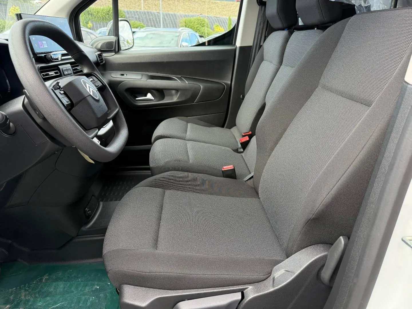 Vue intérieure côté conducteur du Citroën Berlingo Fourgon XL Diesel 130ch 2026 avec sièges tissu gris et volant multifonction.