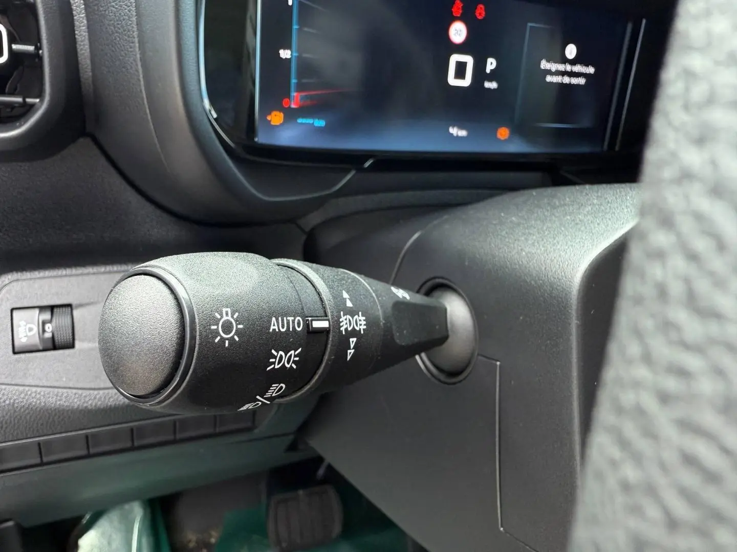 Gros plan sur la commande des phares à gauche du volant dans l'habitacle du Citroën Berlingo Fourgon XL Diesel 2026.