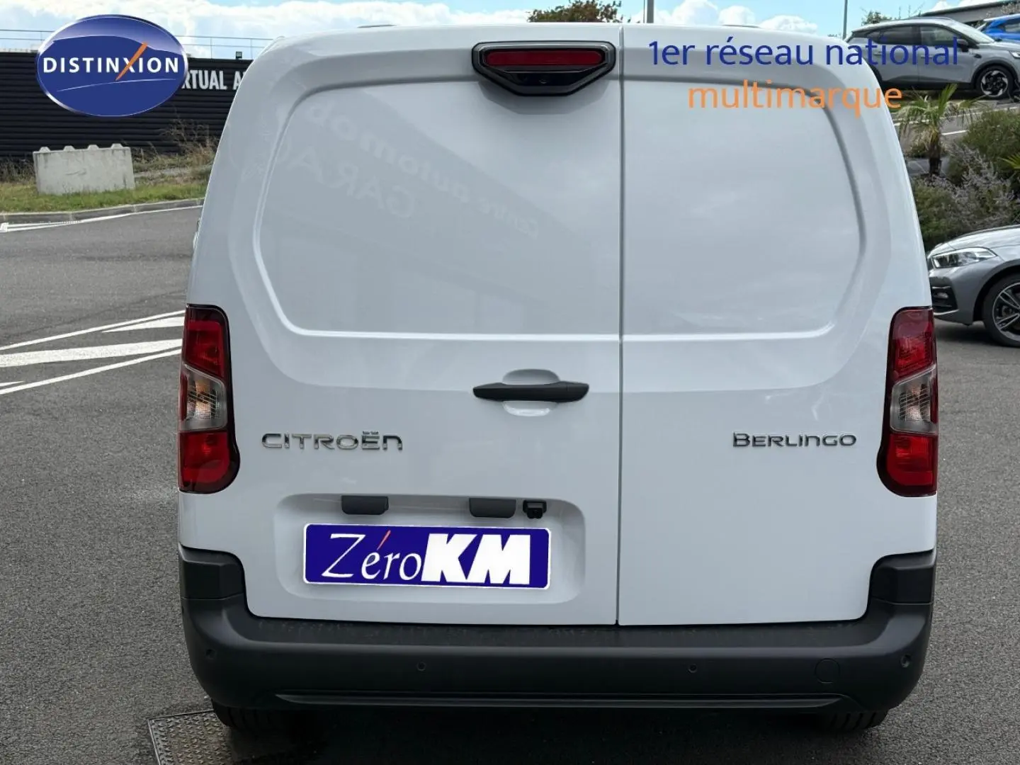 Vue arrière d’un Citroën Berlingo Fourgon XL blanc Icy avec double portes arrière fermées sur parking.