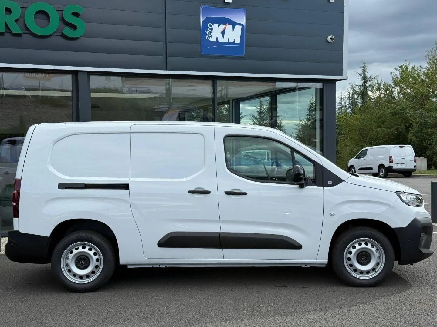 Vue de profil côté gauche d’un Citroën Berlingo Fourgon XL Diesel blanc Icy avec porte latérale coulissante noire.