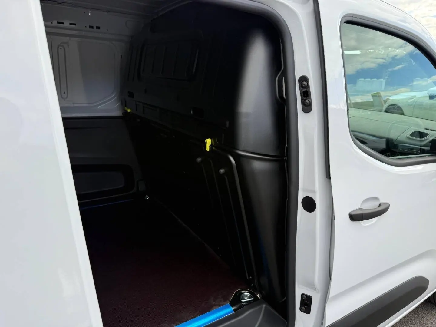 Vue côté droit sur la porte latérale ouverte du Citroën Berlingo Fourgon XL Diesel blanc Icy, montrant l’espace de chargement vide.