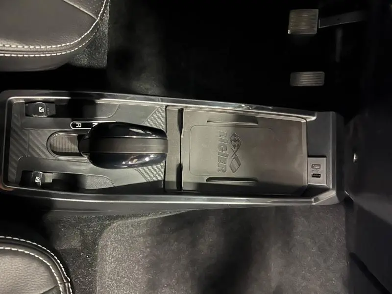 Vue rapprochée de la console centrale grise du Ligier JS50 Sport Elite 2025 avec levier de boîte automatique et logo visible.