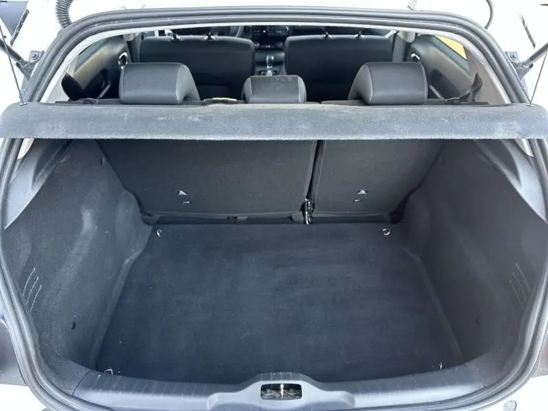 Coffre ouvert vu de l'arrière d'une Citroën C4 Cactus blanche 2018, montrant l'espace de chargement et les sièges arrière.