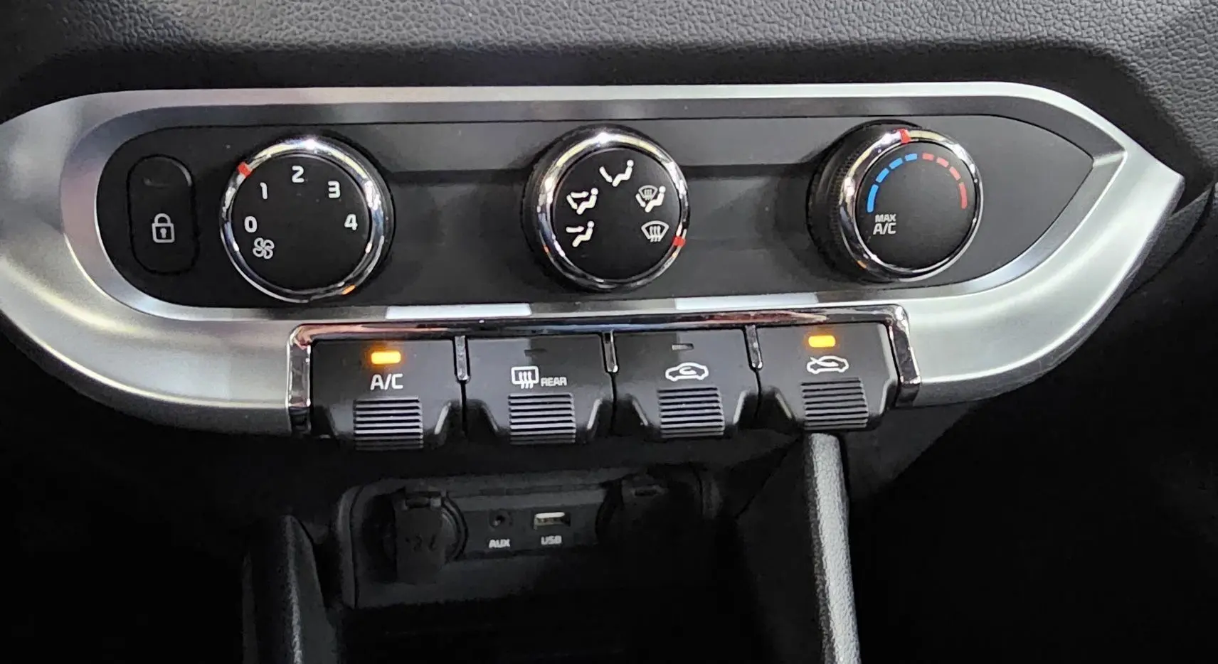 Détail du tableau de bord de la Kia Rio III 2015 montrant les commandes de climatisation et ventilation avec boutons rétroéclairés.