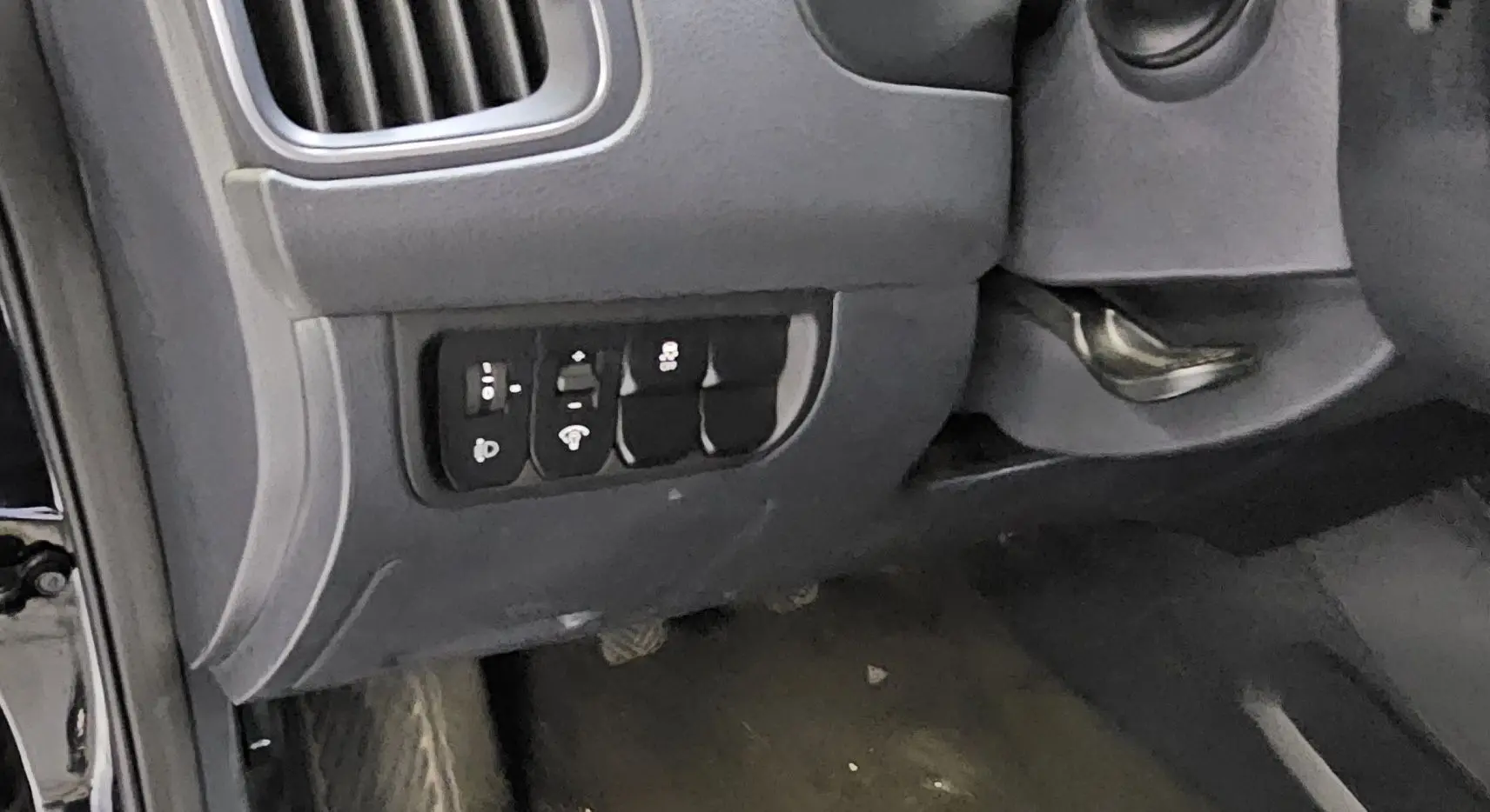 Vue rapprochée du tableau de bord côté gauche de la KIA RIO III noire, montrant les commandes de réglage et ventilation.