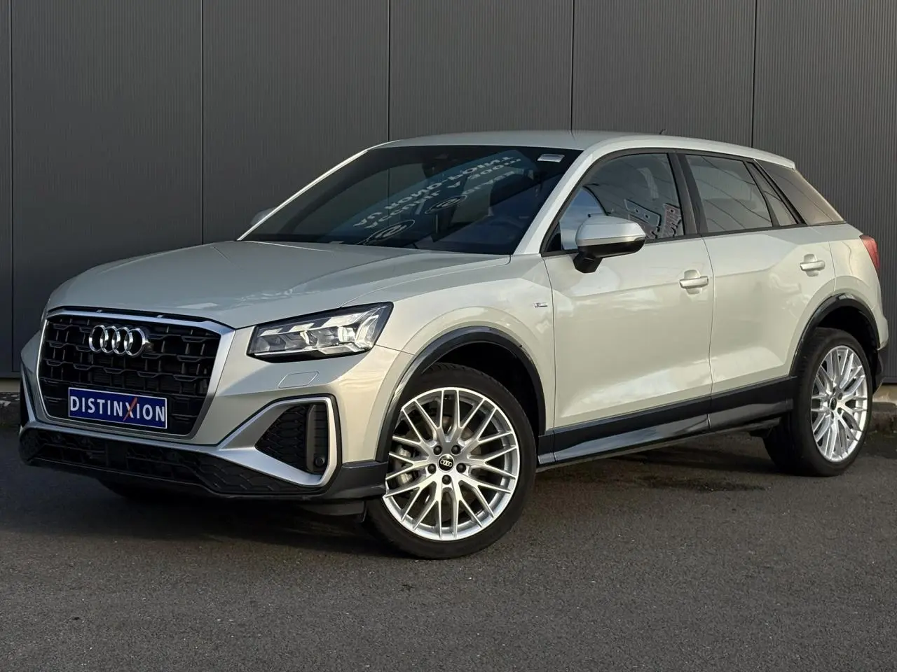 Audi Q2 35 TDI S-Line argent rosé, vue 3/4 avant droit, avec jantes alliage et calandre noire distinctive.