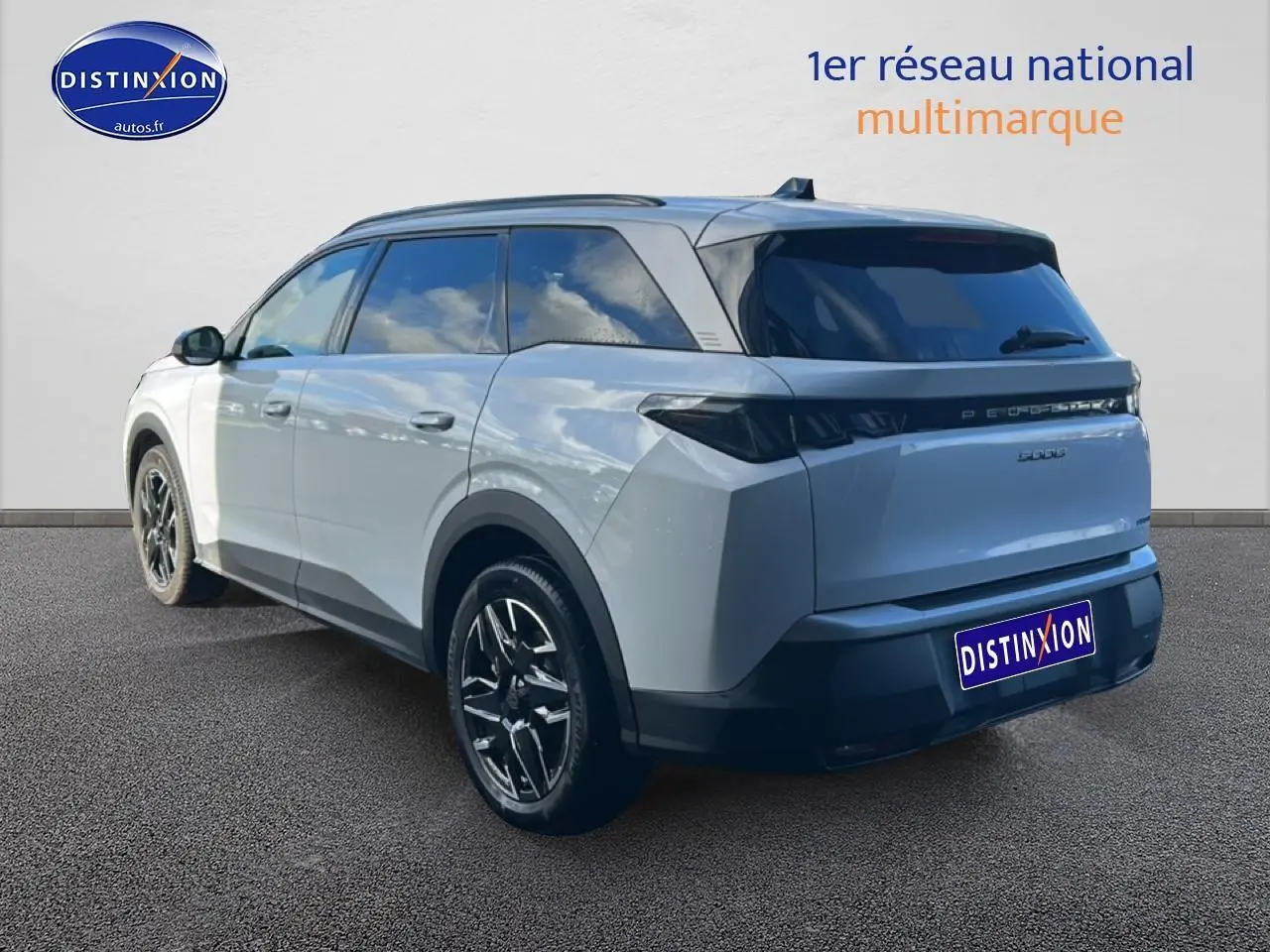 Vue 3/4 arrière droite d’un Peugeot 5008 Hybrid 145 allure blanc okenite avec jantes alu et vitres arrière surteintées.