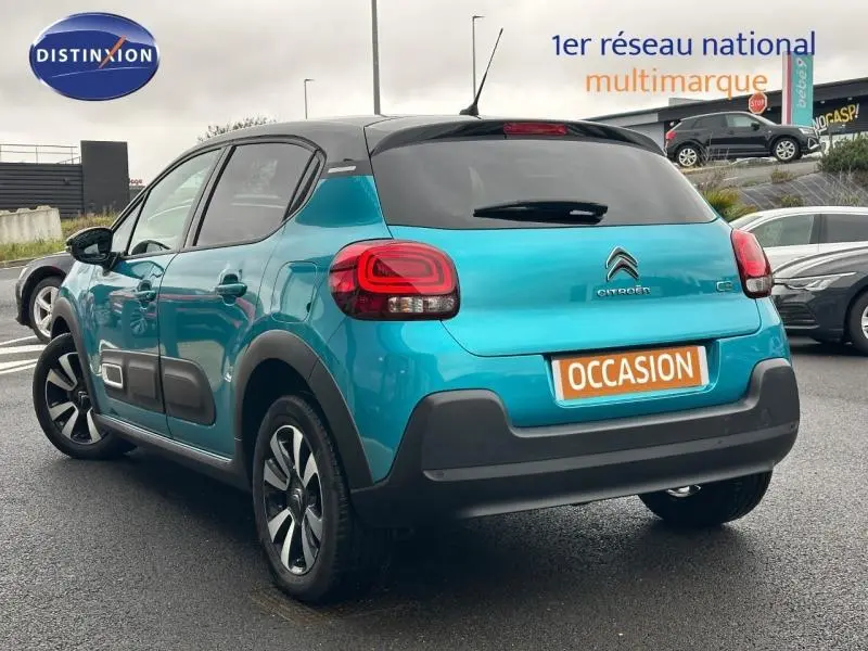 Vue 3/4 arrière droite d'une Citroën C3 2023 bicolore Spring Blue et Noir Perla Nera avec jantes alu et vitres surteintées.