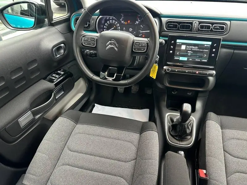 Vue intérieure avant de la Citroën C3 2023, tableau de bord avec volant, écran tactile et sellerie gris Mica.