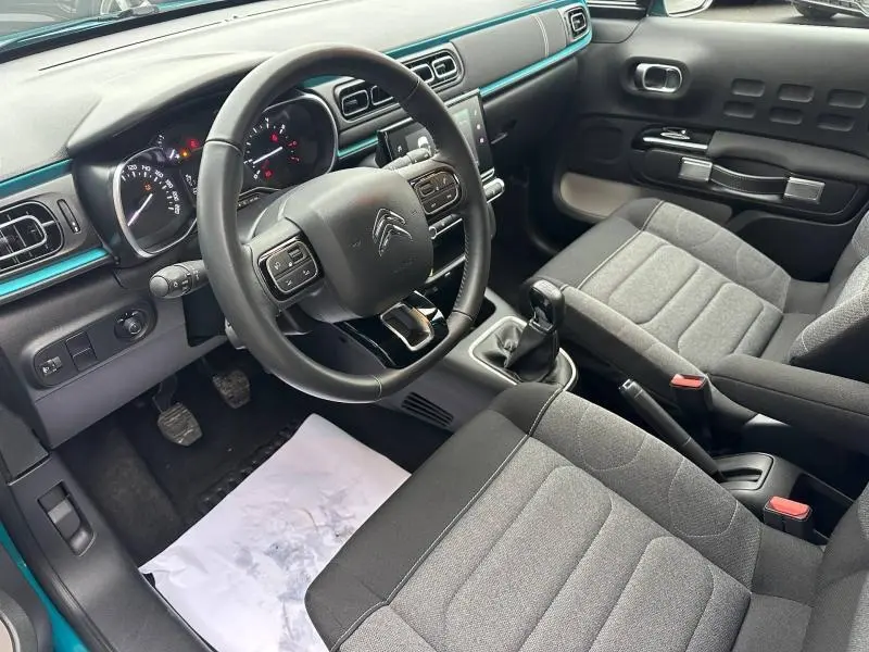 Vue intérieure côté conducteur de la Citroën C3 2023 avec tableau de bord noir et touches bleu Spring Blue.