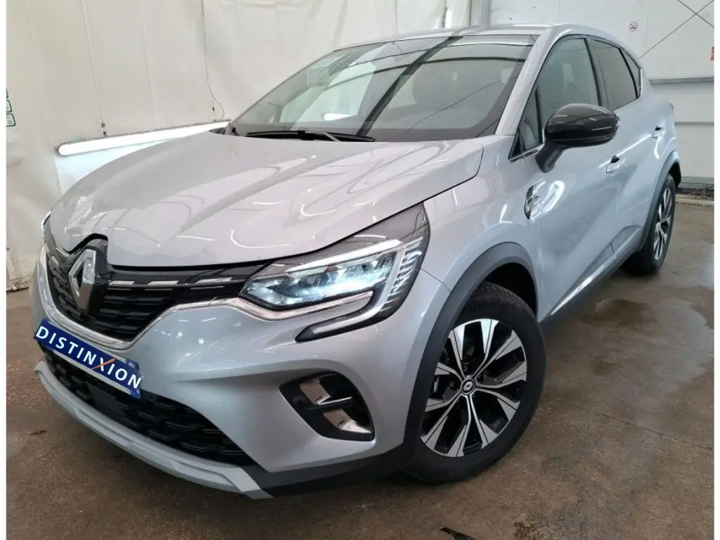 Renault Captur II Techno gris Highland en 3/4 avant droit, avec jantes alliage noir et phares LED allumés.