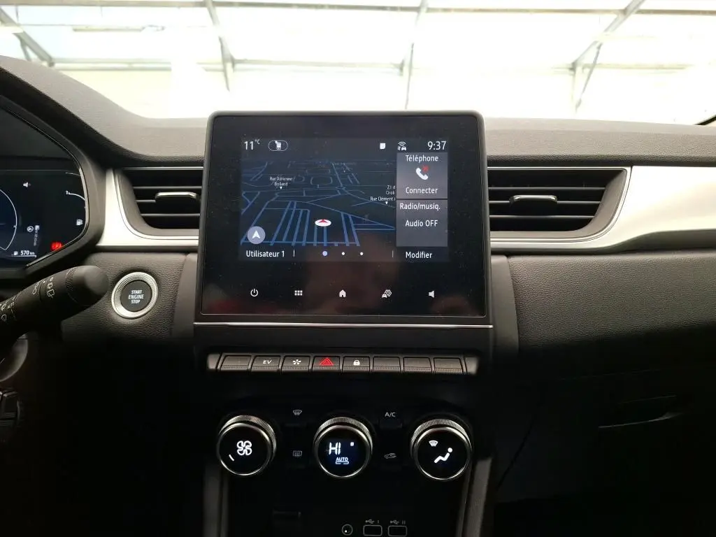 Vue intérieure centrée sur l'écran tactile 7'' du système multimédia Easy Link du Renault Captur gris Highland 2023.