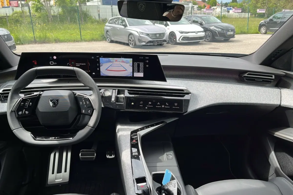 Vue intérieure avant du Peugeot 5008 Hybrid 145 GT Alcantara avec tableau de bord numérique et volant cuir multifonctions.