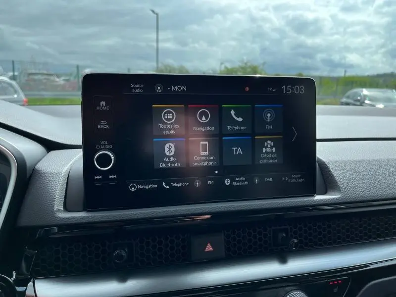 Écran tactile central du tableau de bord du Honda CR-V 2024 affichant les options de navigation et audio, vue intérieure avant.
