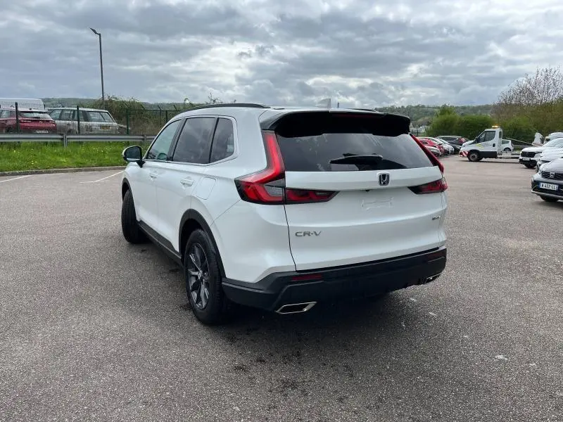 Vue 3/4 arrière droite du Honda CR-V 2024 blanc platine nacré avec feux arrière LED et jantes alliage noires.