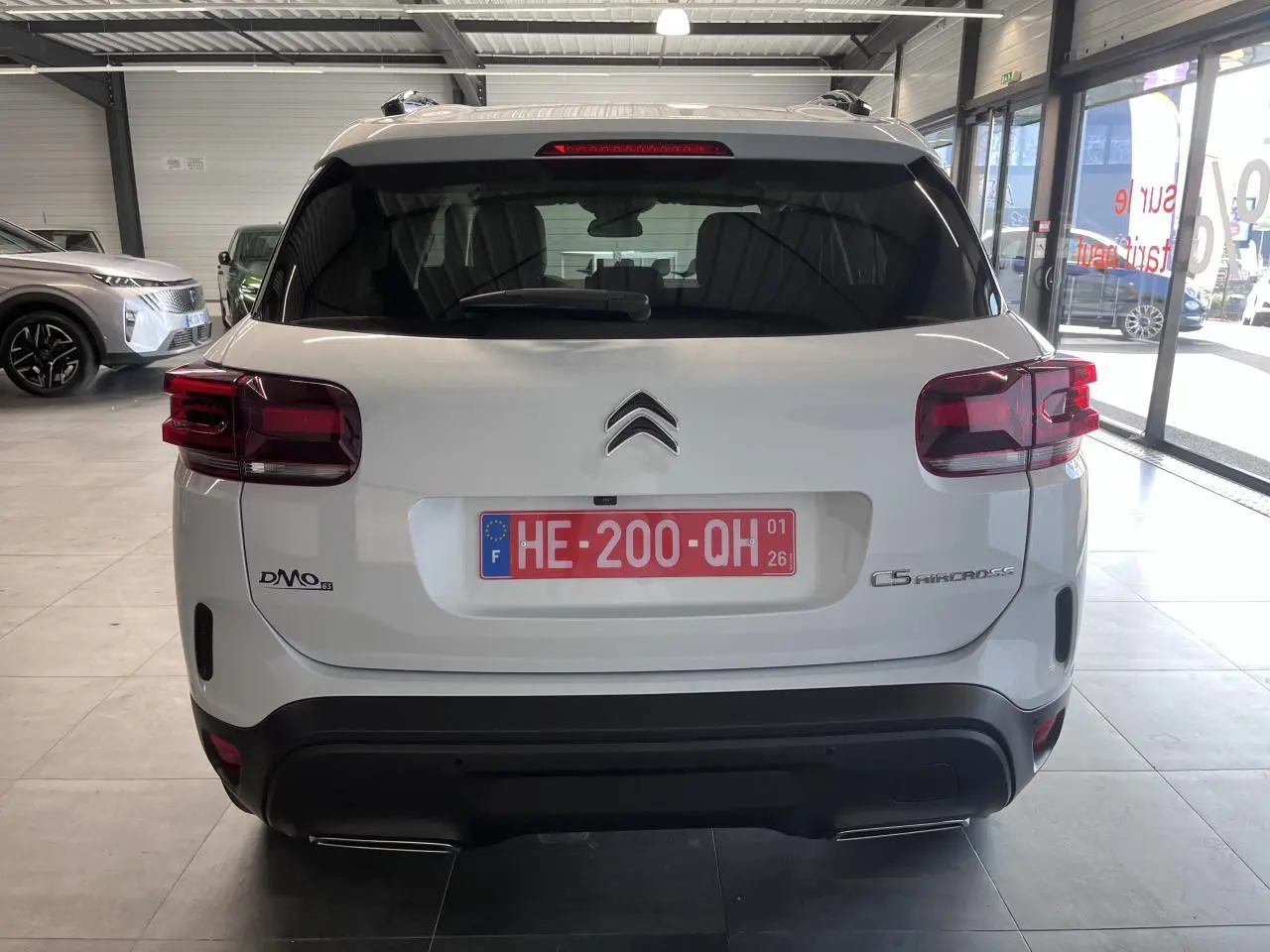 Vue arrière d'un Citroën C5 Aircross blanc nacré avec feux arrière LED et double sortie d'échappement chromée.