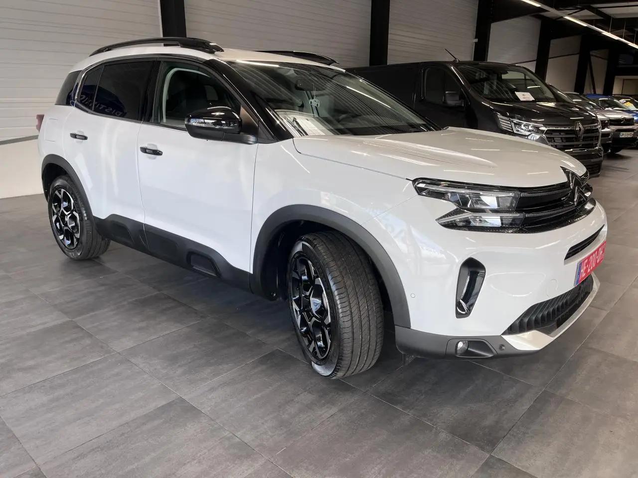 Citroën C5 Aircross blanc nacré en 3/4 avant droit, avec jantes alliage bi-ton et détails noirs brillants.