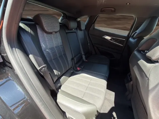 Vue intérieure côté gauche des sièges arrière en tissu gris et cuir noir du Renault Austral Techno Full Hybrid 2025.