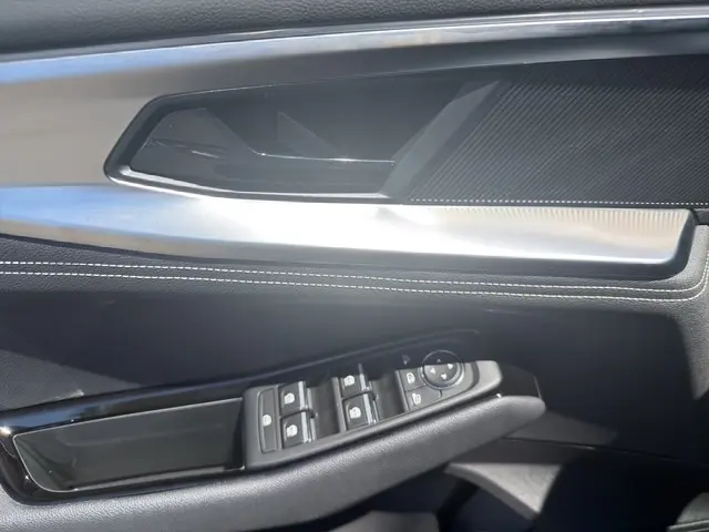 Gros plan sur la poignée intérieure et les commandes des vitres côté conducteur du Renault Austral noir, finition Techno.