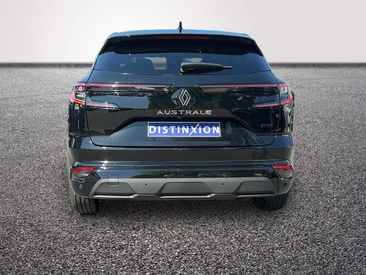 Vue arrière d’un Renault Austral noir avec feux LED reliés et logo au centre sur fond clair.