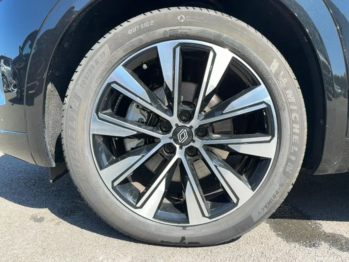 Gros plan sur la roue avant droite noire du Renault Austral 2025 avec jante alliage bicolore et pneu Michelin.