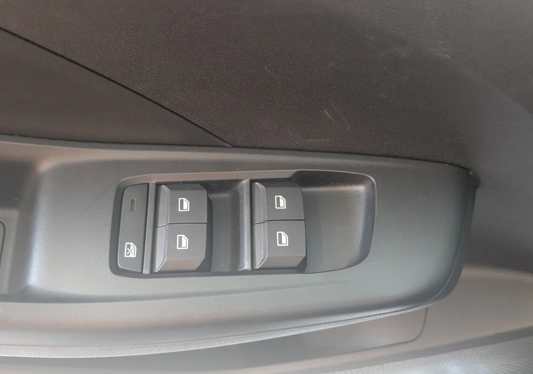 Gros plan sur les commandes des vitres électriques côté conducteur de la MG3 1.5L Hybrid+ 195ch Luxury, intérieur gris noir.