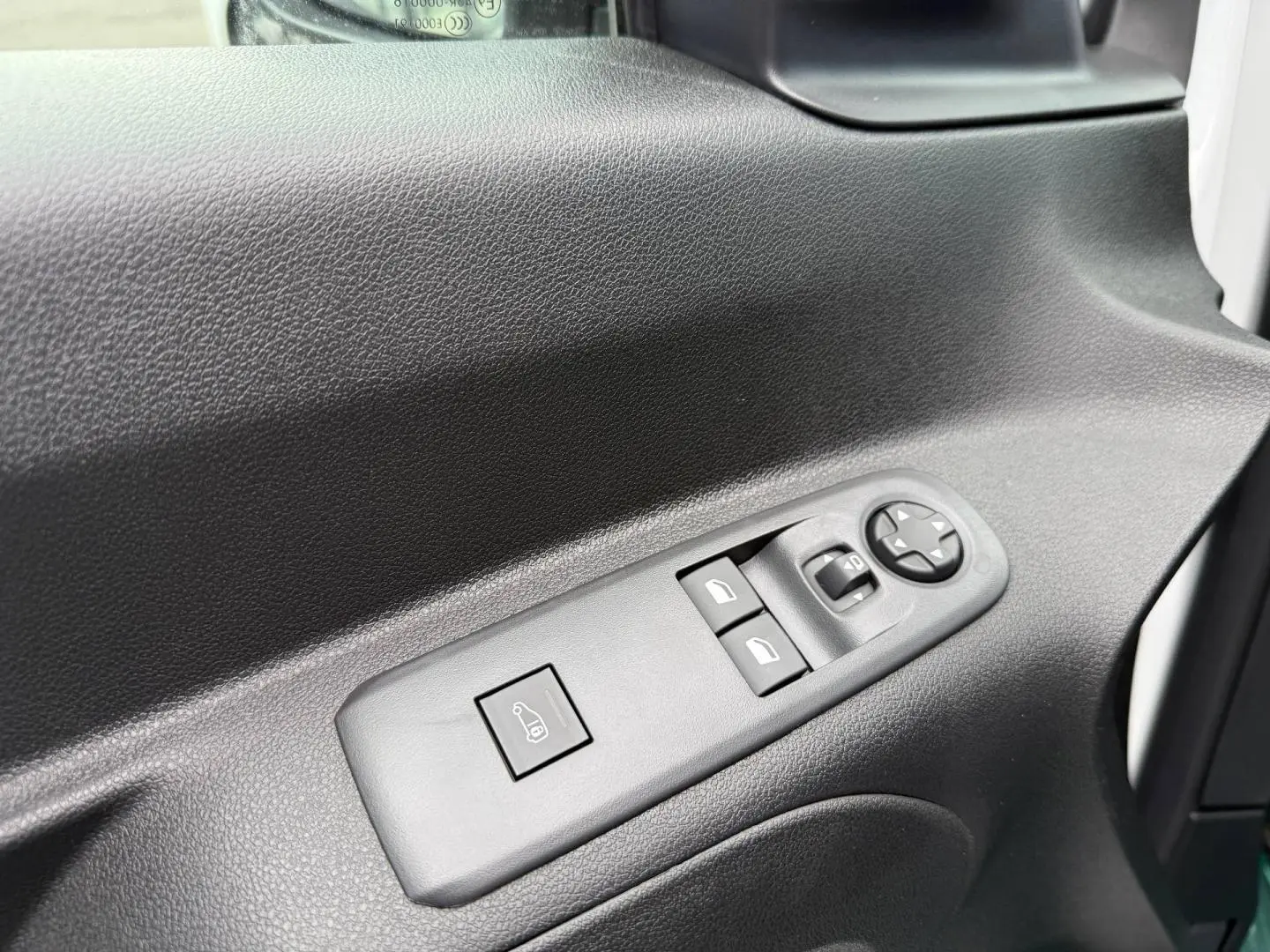 Gros plan sur les commandes de vitres et rétroviseurs sur la porte côté gauche du Citroën Berlingo Fourgon XL blanc Icy.