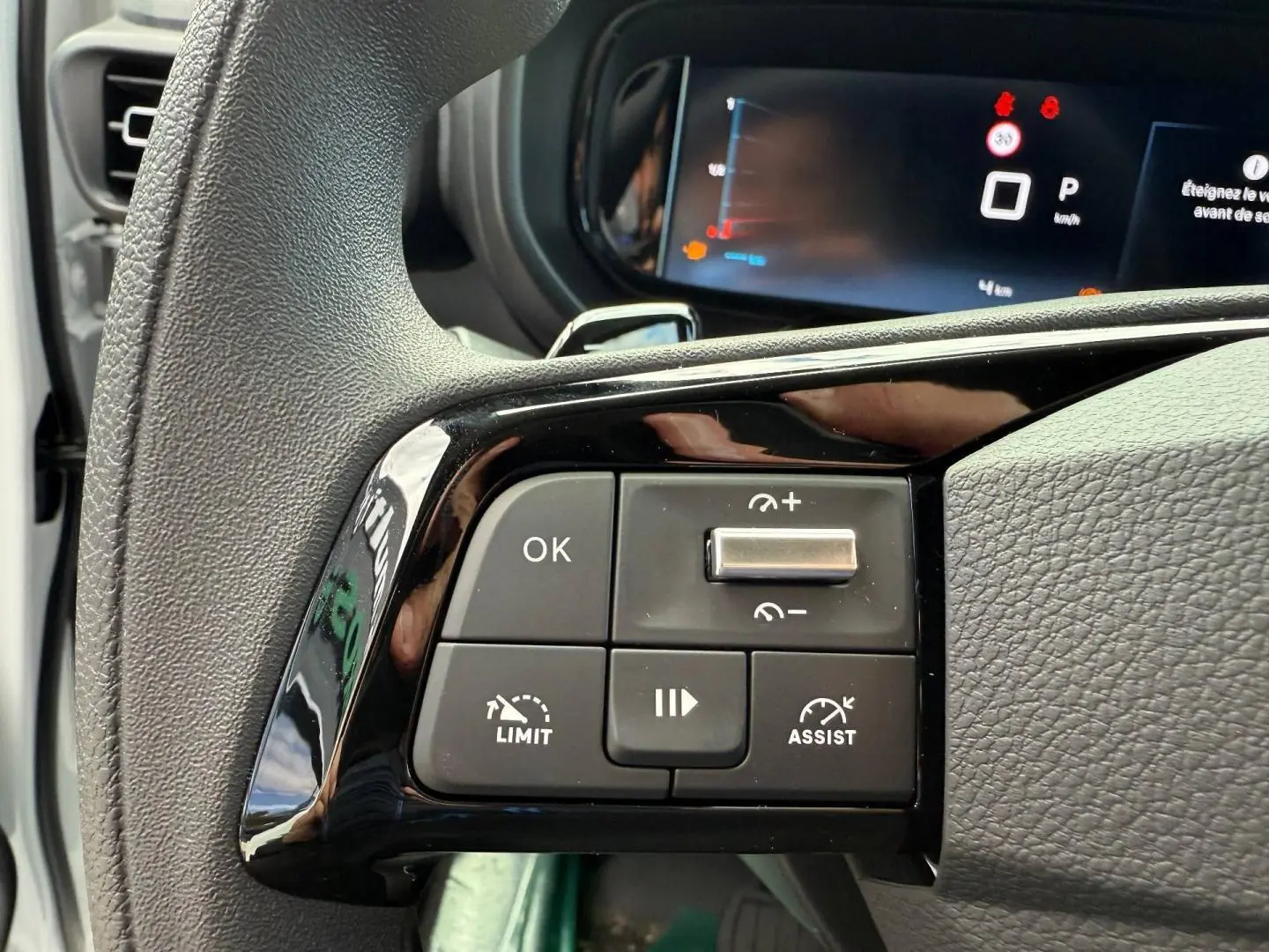 Gros plan sur les commandes multifonctions du volant noir du Citroën Berlingo Fourgon XL Diesel 2026, tableau de bord en arrière-plan.