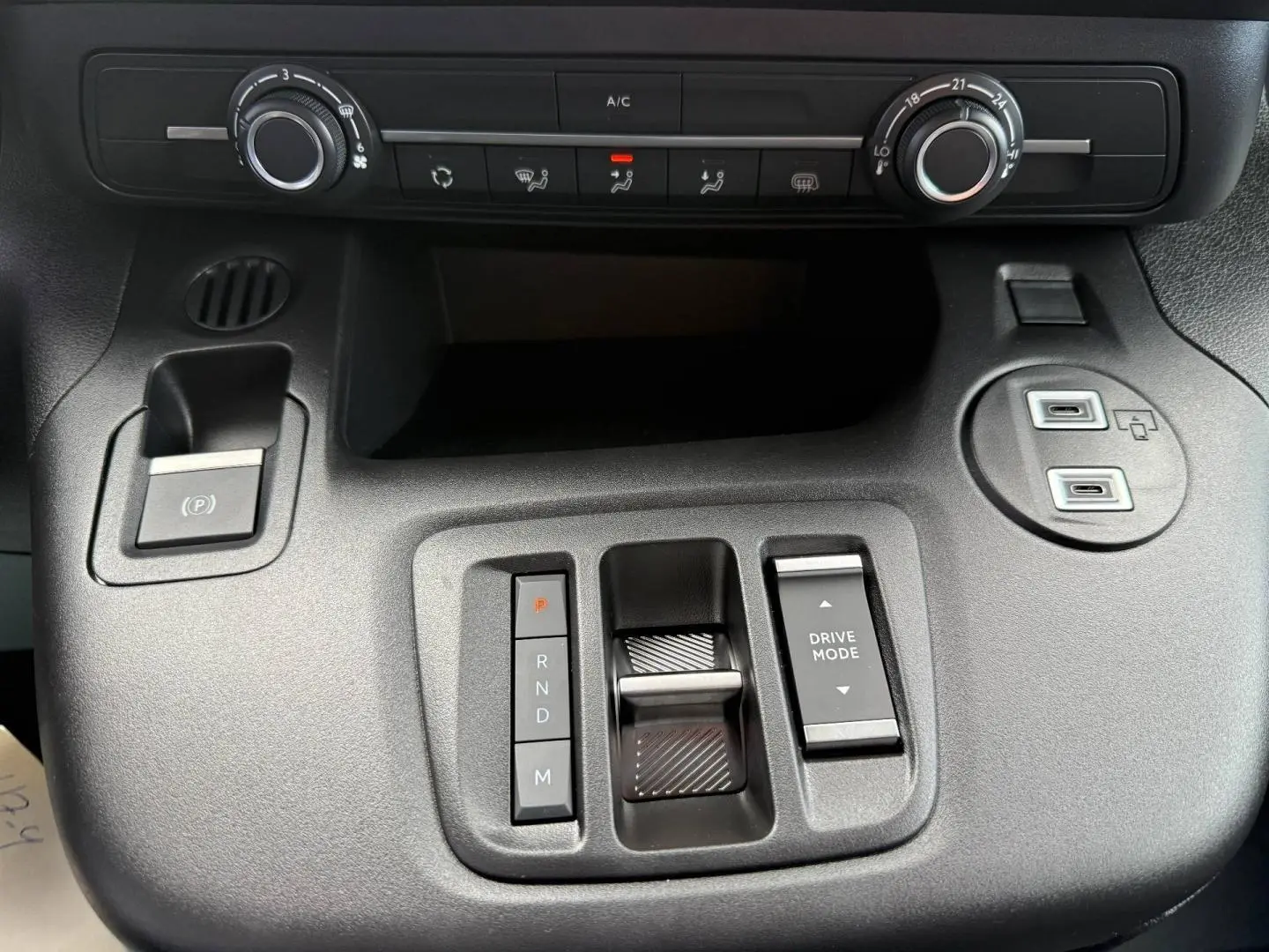 Vue rapprochée de la console centrale noire du Citroën Berlingo Fourgon XL avec commandes de climatisation et boutons de boîte auto.