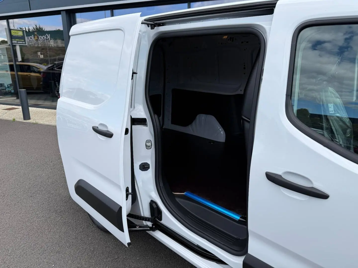 Vue côté droit d’un Citroën Berlingo Fourgon XL blanc Icy avec porte latérale coulissante ouverte montrant l’espace de chargement.